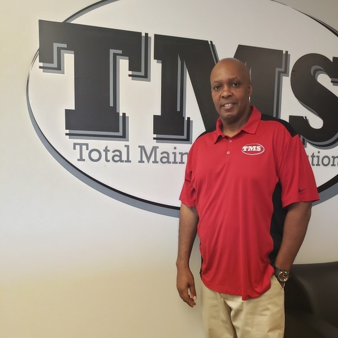 LeRoy in front of TMS logo