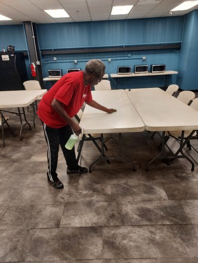 a person cleaning and wiping off the top of a table